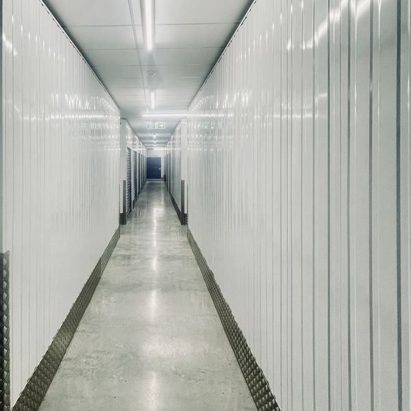 Wide, well-lit corridor between storage units
